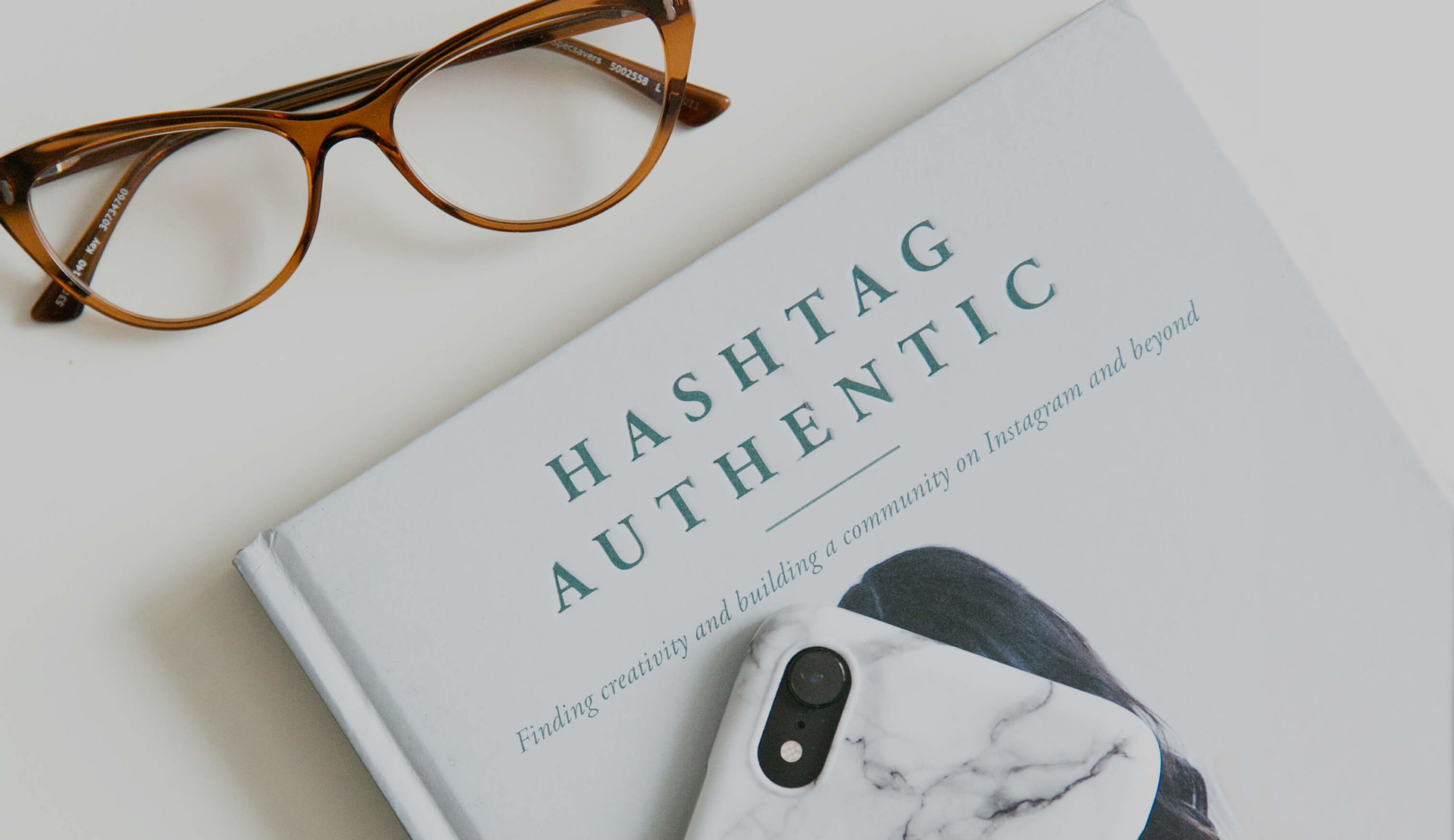 Hashtag book with iPhone and glasses
